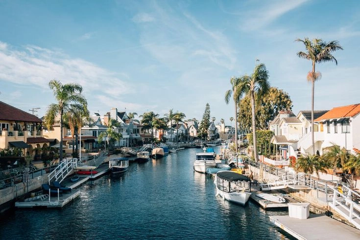 Beautiful canal neighborhood in Long Beach, California, lined with palm trees, docked boats, and residential homes — patrolled by BlueWolf International Security for premium safety.